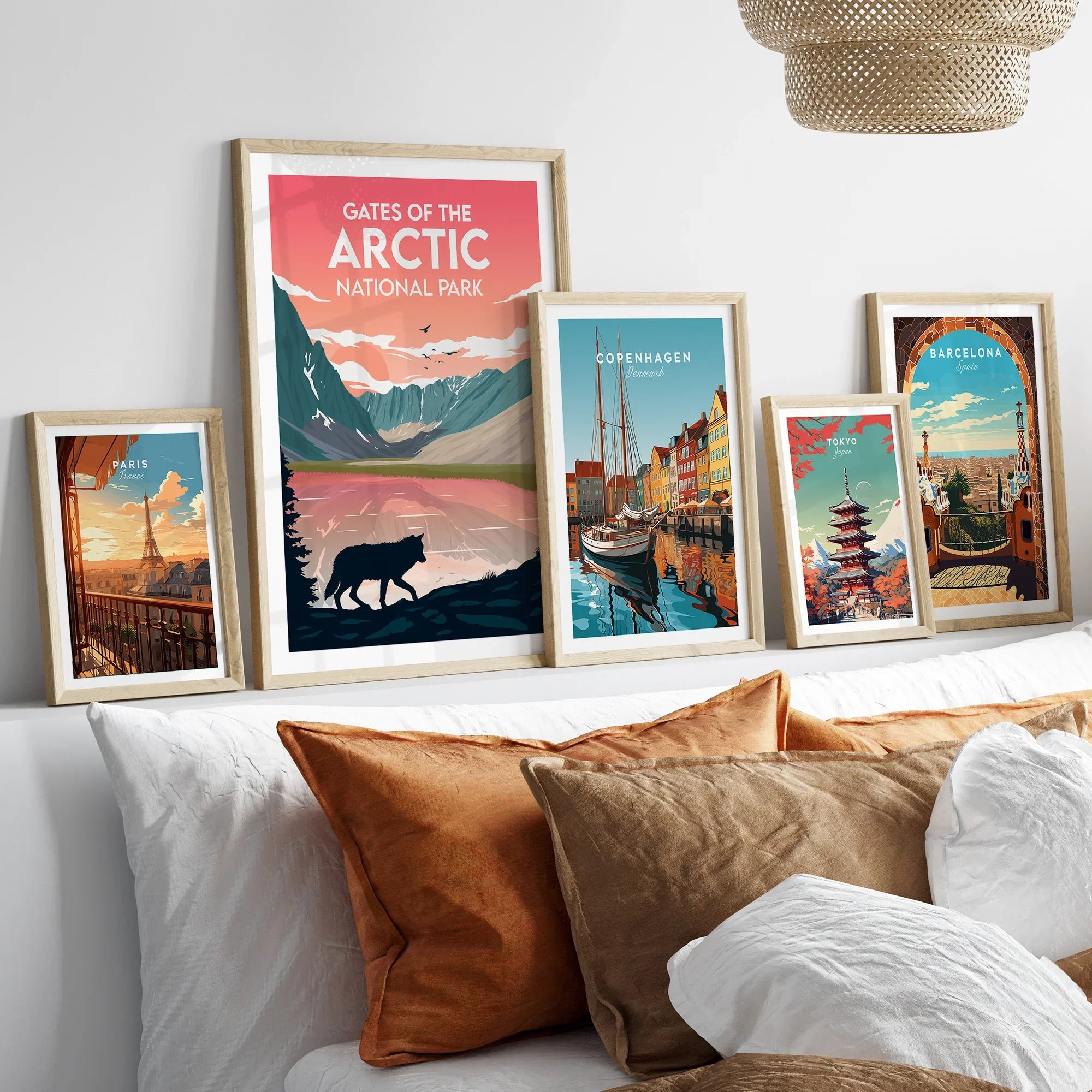 Set of five framed travel art prints above a bed, featuring national park and city posters.