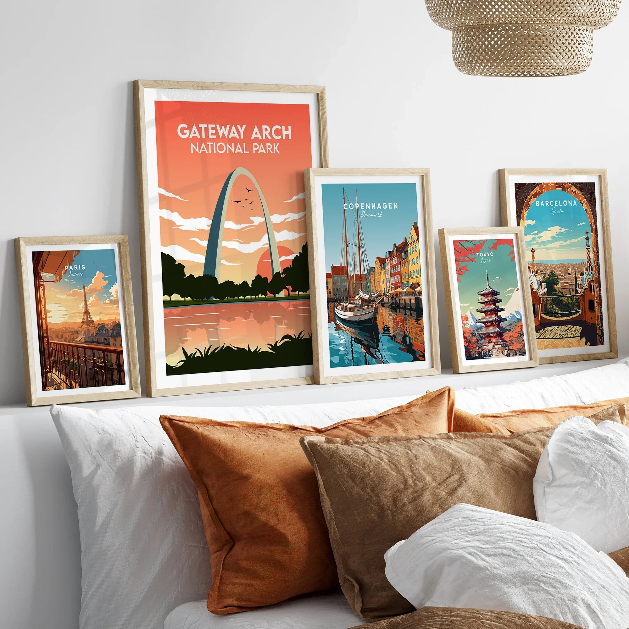 Framed travel and national park art prints above a bed with natural wood frames