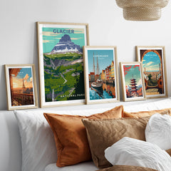 Set of five framed travel posters with city skylines and national park art above a bed