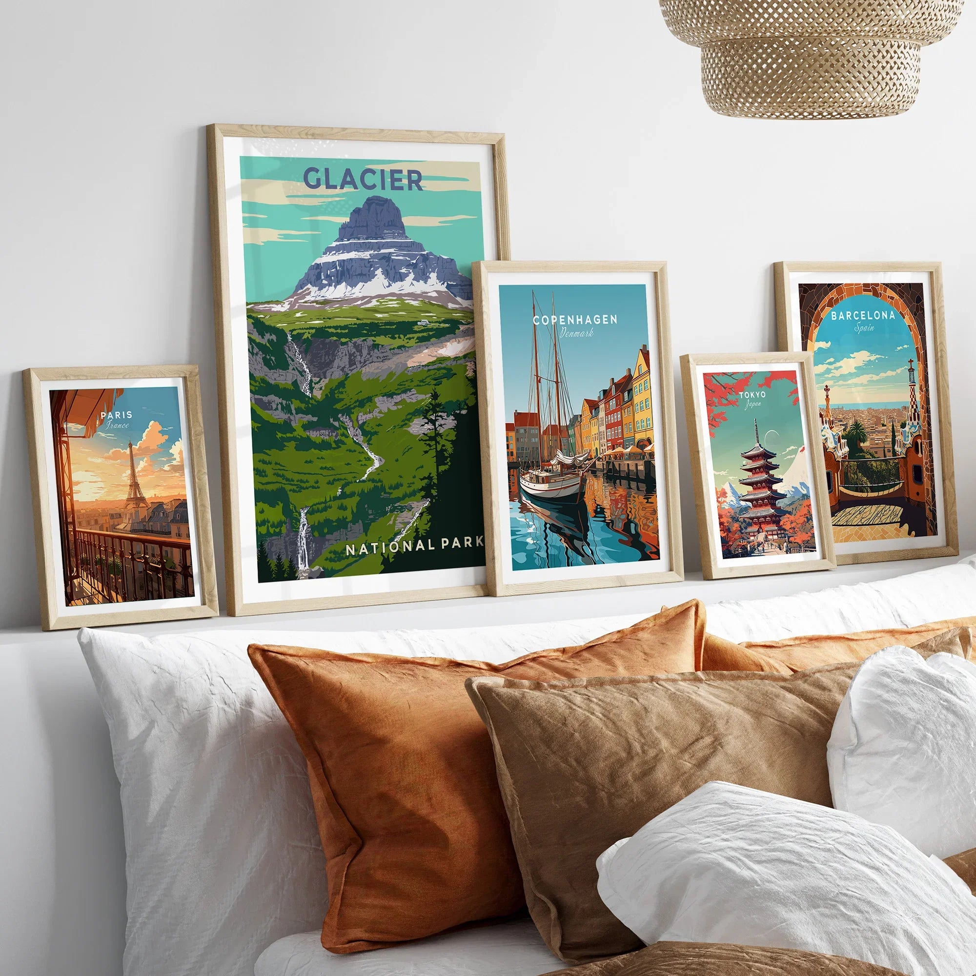 Set of five framed travel posters with city skylines and national park art above a bed