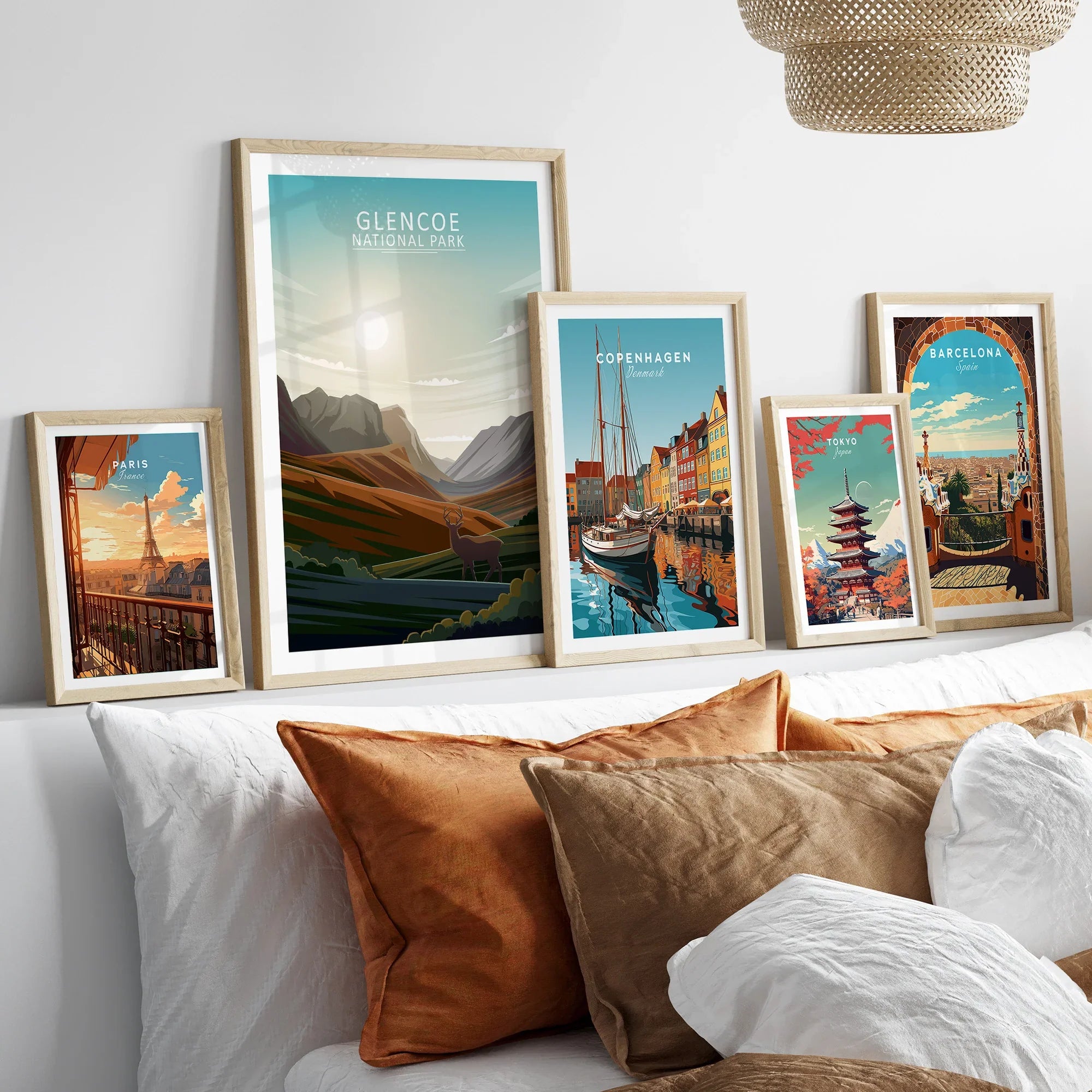 Set of five framed travel art prints above bed, featuring city skylines and national park scenes.