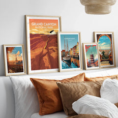 Framed travel posters of Grand Canyon, Paris, Copenhagen, Tokyo, and Barcelona above bed