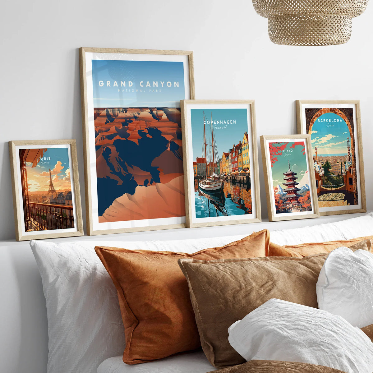 Framed travel art prints of Grand Canyon, Paris, Copenhagen, Tokyo, and Barcelona above a bed