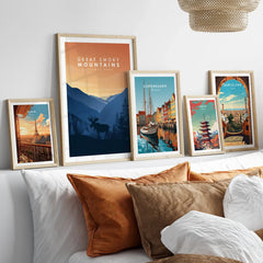 Framed travel and national park art prints above bed, featuring Paris, Great Smoky Mountains, Copenhagen, Tokyo, and Barcelona scenes.