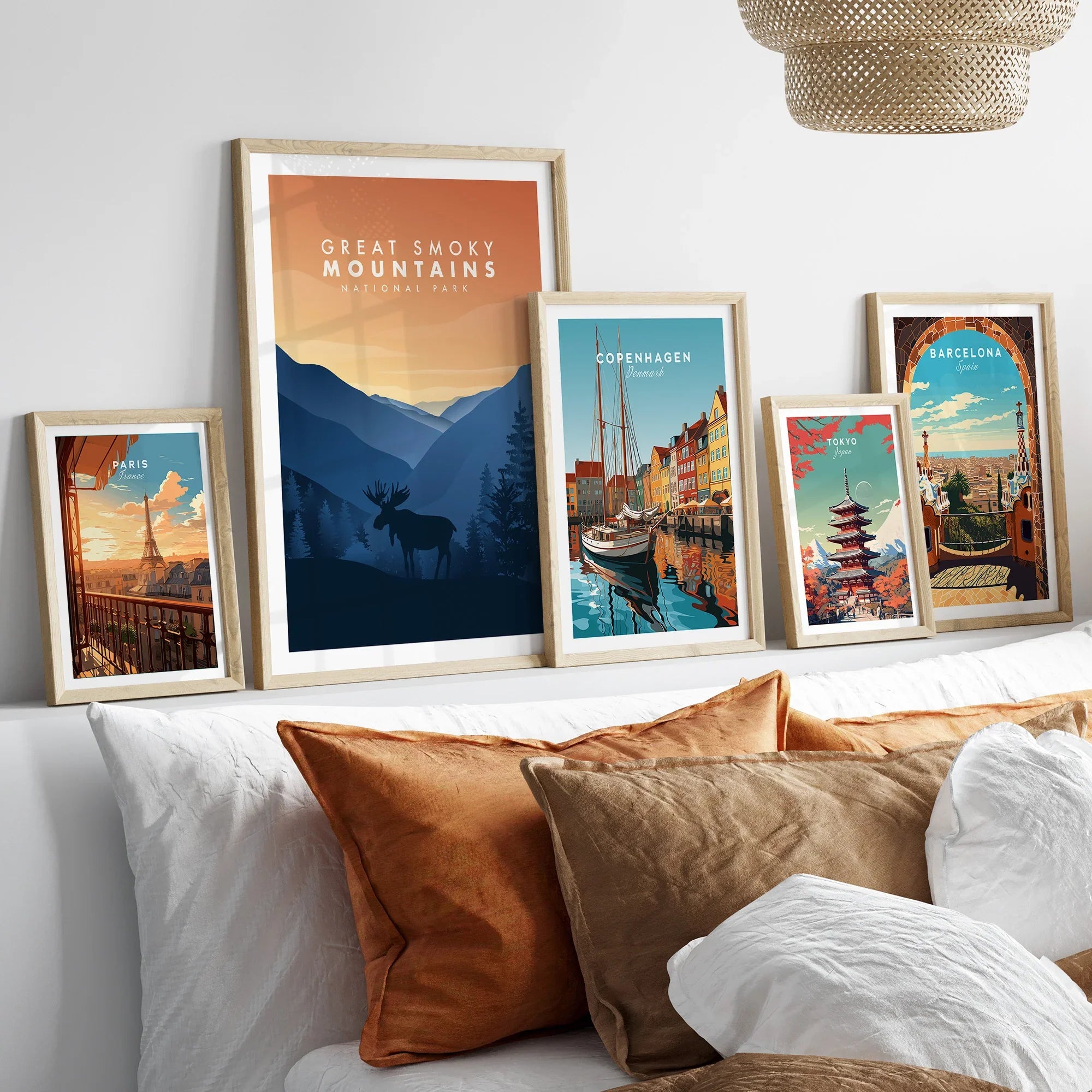 Framed travel and national park art prints above bed, featuring Paris, Great Smoky Mountains, Copenhagen, Tokyo, and Barcelona scenes.