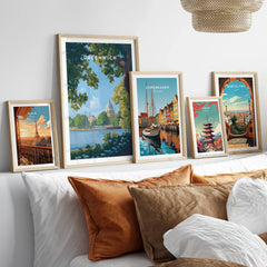 Framed travel posters of Paris, Greenwich, Copenhagen, Tokyo, and Barcelona above bed