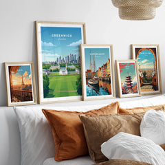 Set of five framed travel city posters including Greenwich, Copenhagen, Paris, Tokyo, Barcelona above a bed with natural wood frames.
