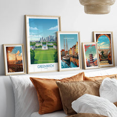 Framed travel art prints of Paris, Greenwich, Copenhagen, Tokyo, and Barcelona above bed