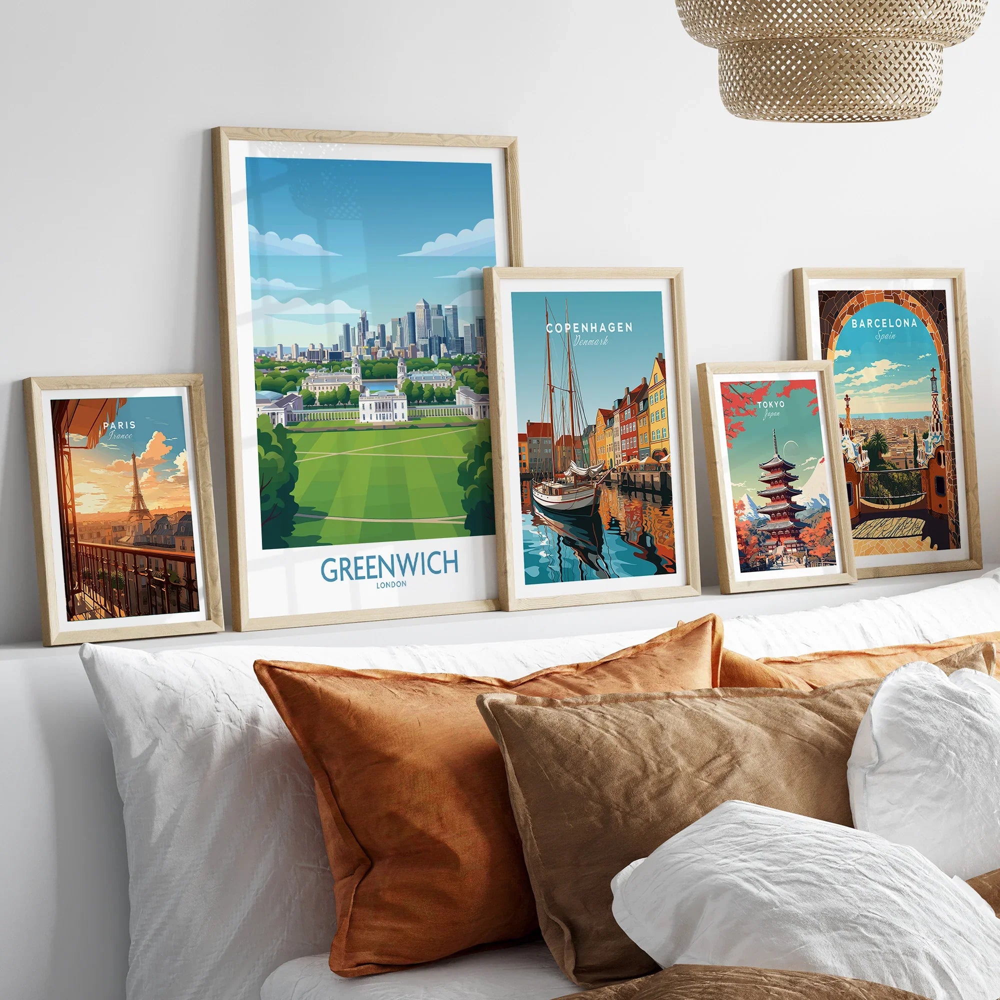 Framed travel art prints of Paris, Greenwich, Copenhagen, Tokyo, and Barcelona above bed