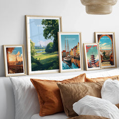 Framed travel city art prints above bed, featuring Paris, Greenwich, Copenhagen, Tokyo, Barcelona.
