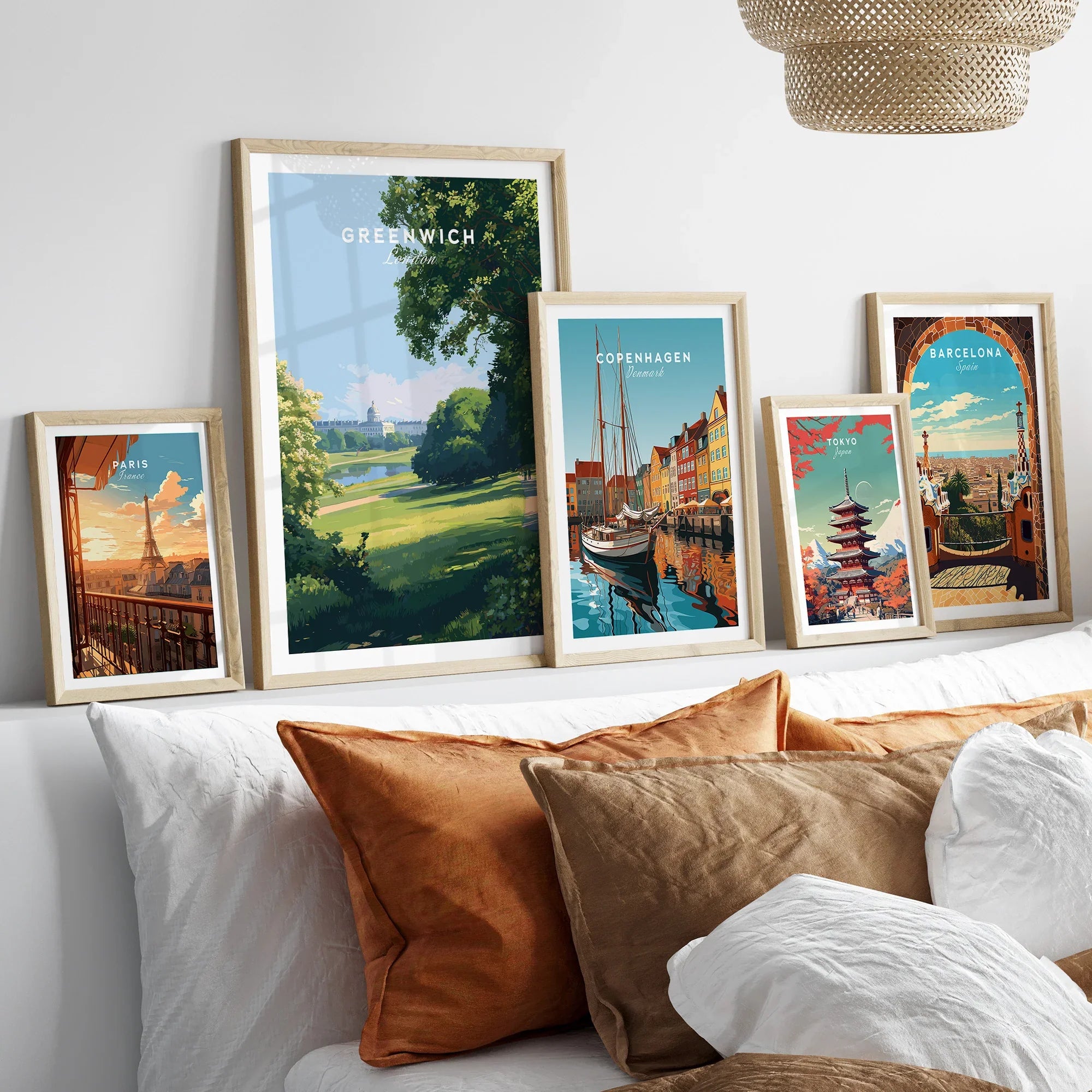 Framed travel city art prints above bed, featuring Paris, Greenwich, Copenhagen, Tokyo, Barcelona.