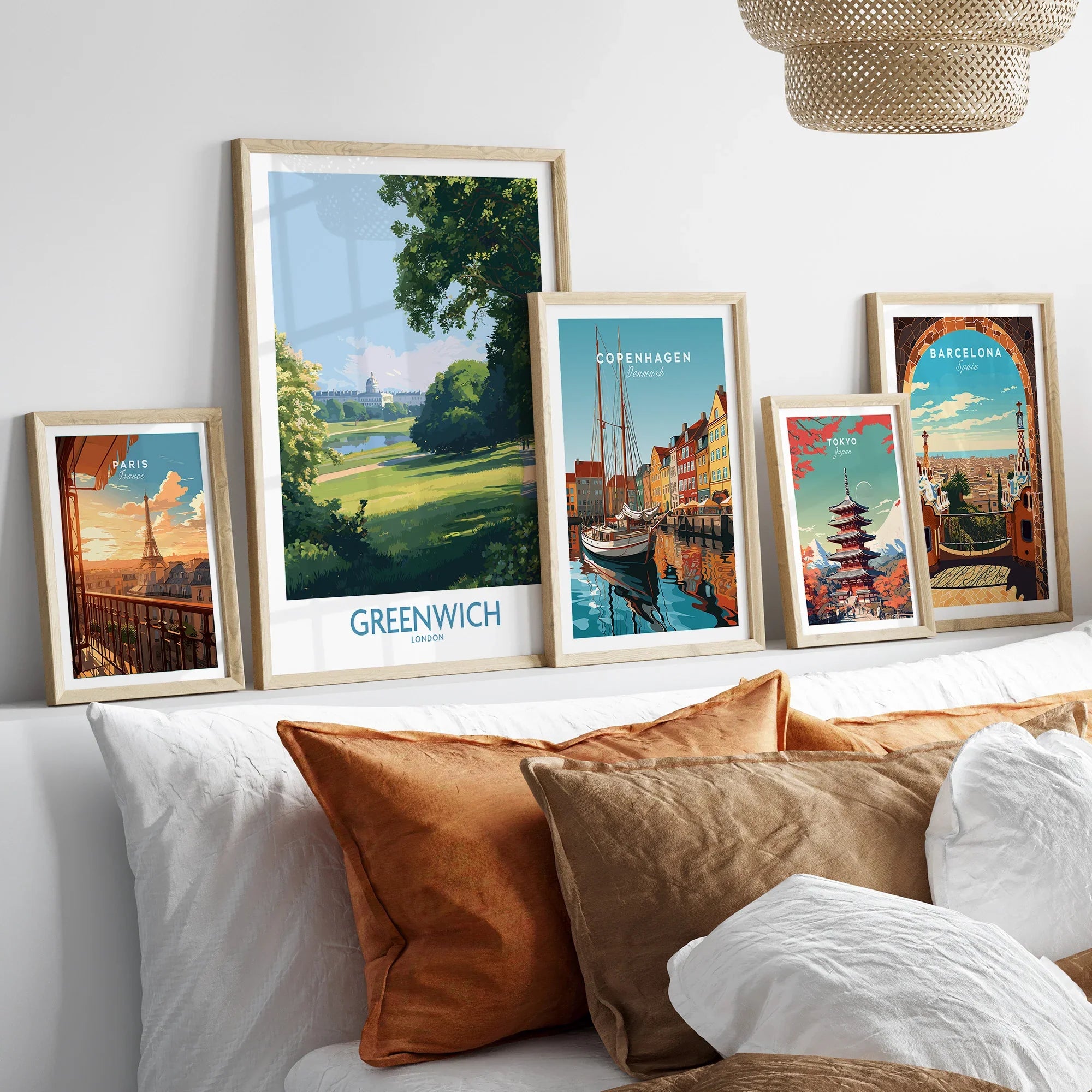 Set of five framed travel posters with city and nature scenes above a modern bed.