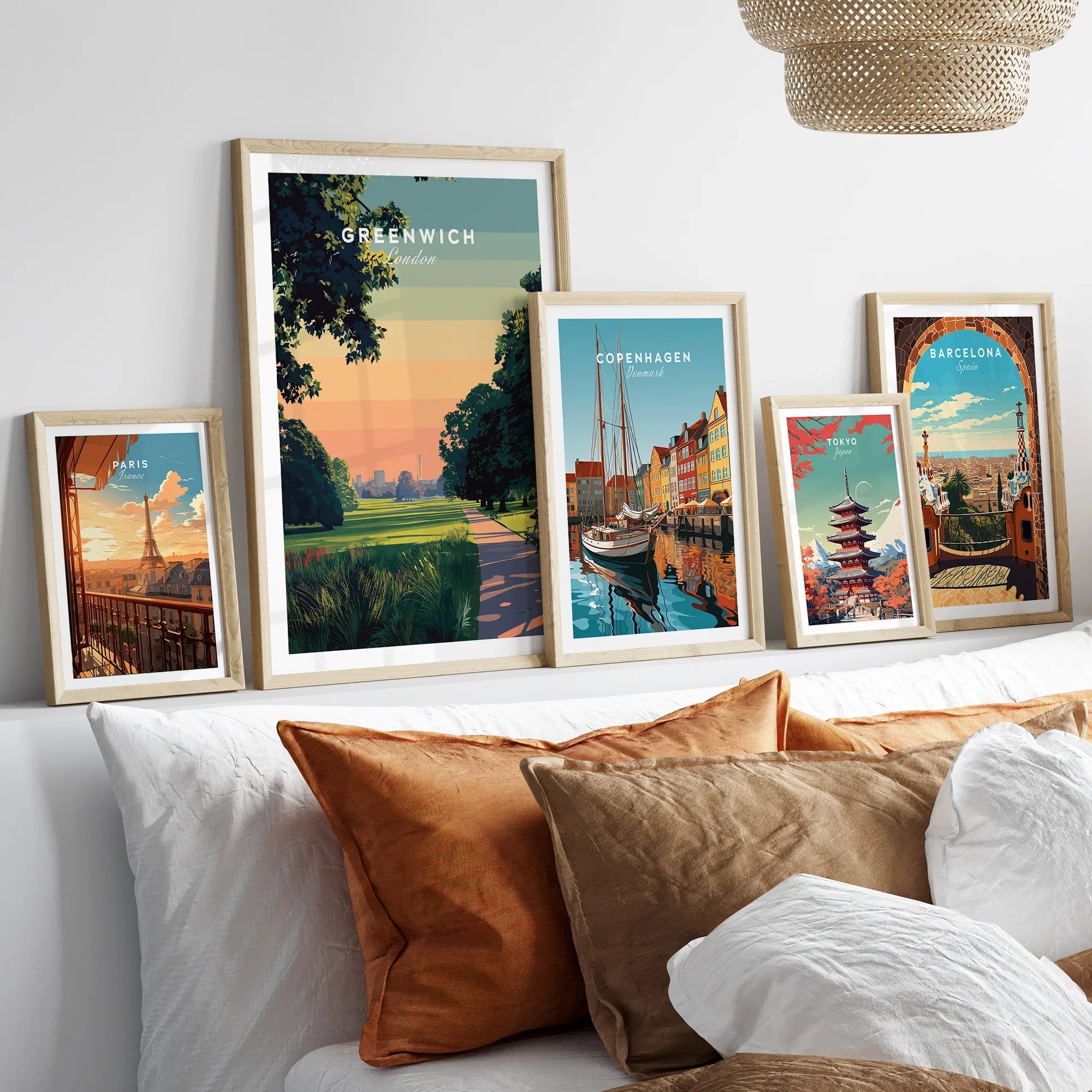 Framed travel posters of Greenwich, Paris, Copenhagen, Tokyo, and Barcelona above a bed