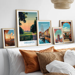 Five framed travel art prints of Paris, Greenwich, Copenhagen, Tokyo, and Barcelona above a bed
