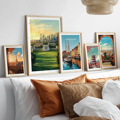 Framed travel posters of world cities above bed, natural wood frames, modern home decor.