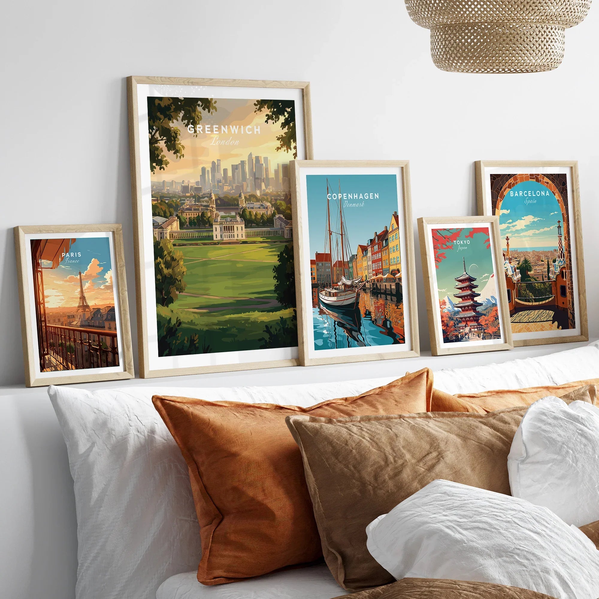 Framed travel posters of Greenwich, Paris, Copenhagen, Tokyo, and Barcelona above a modern bed.