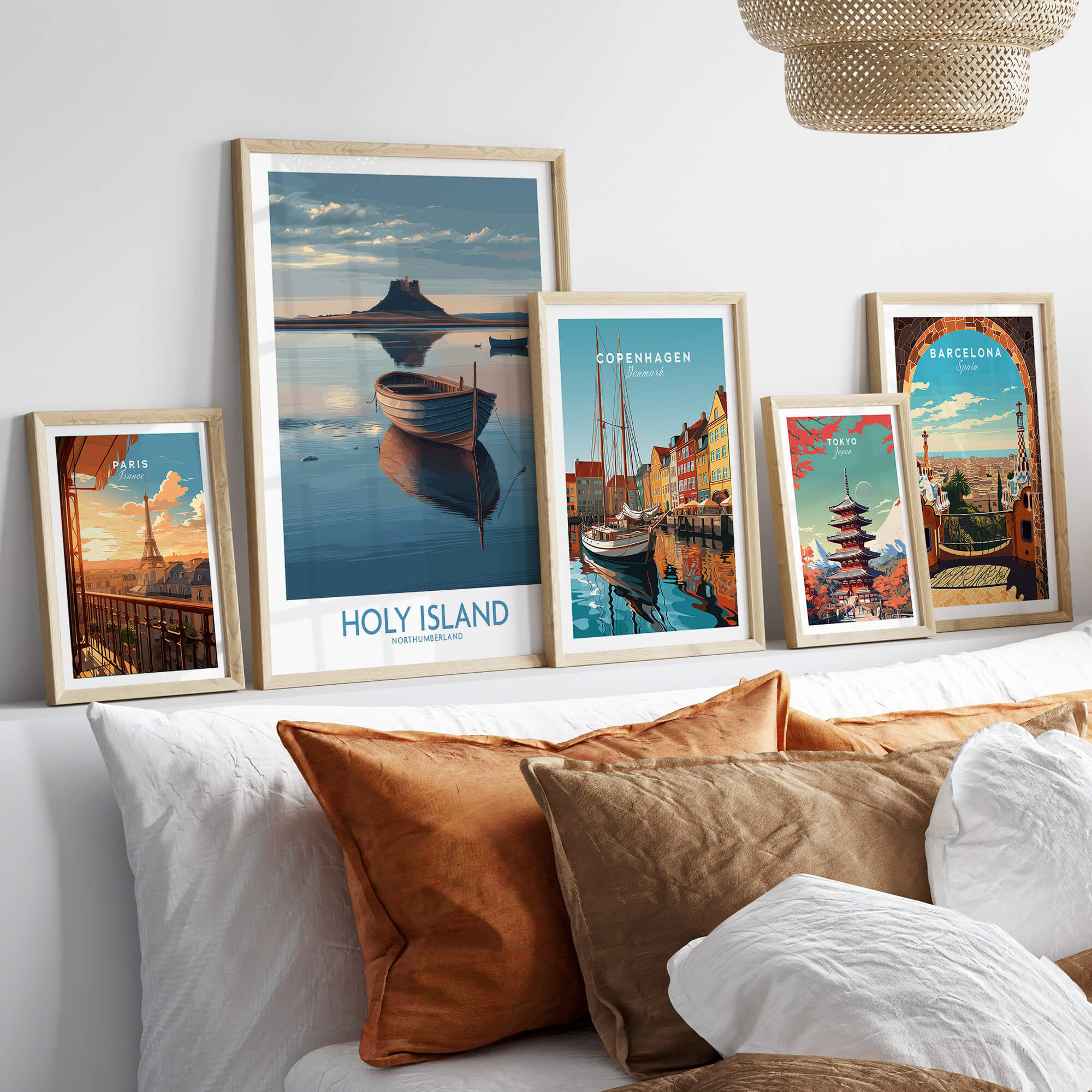 Holy Island Poster Northumberland | Lindisfarne Canvas Print displayed among various travel posters on a sofa.