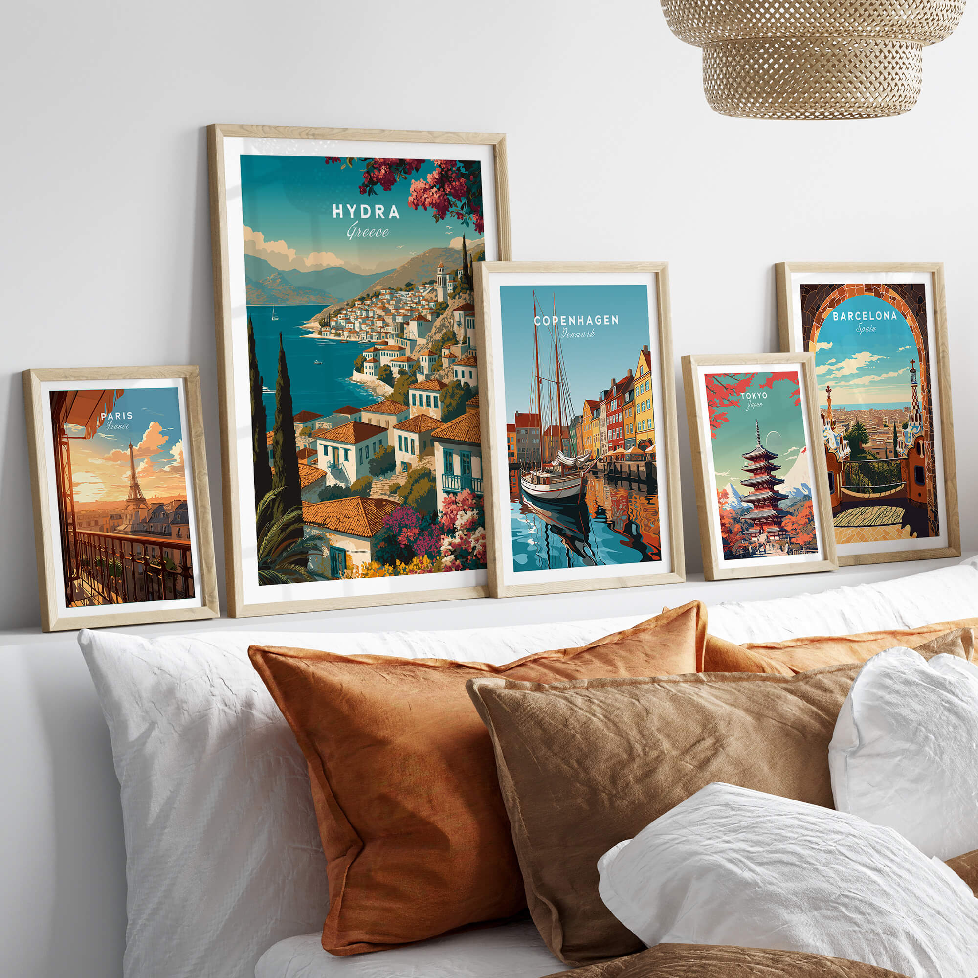 Hydra Greece Wall Art Print | Mediterranean Coastal Town Travel Poster displayed among other travel posters on a cozy sofa.