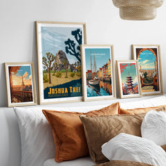 Set of five framed travel prints above bed, featuring Joshua Tree, Paris, Copenhagen, Tokyo, Barcelona.