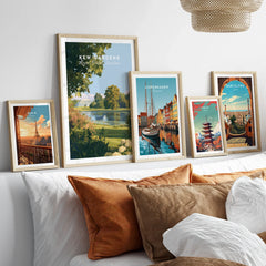 Framed travel posters of Kew Gardens, Copenhagen, Paris, Tokyo and Barcelona above a bed