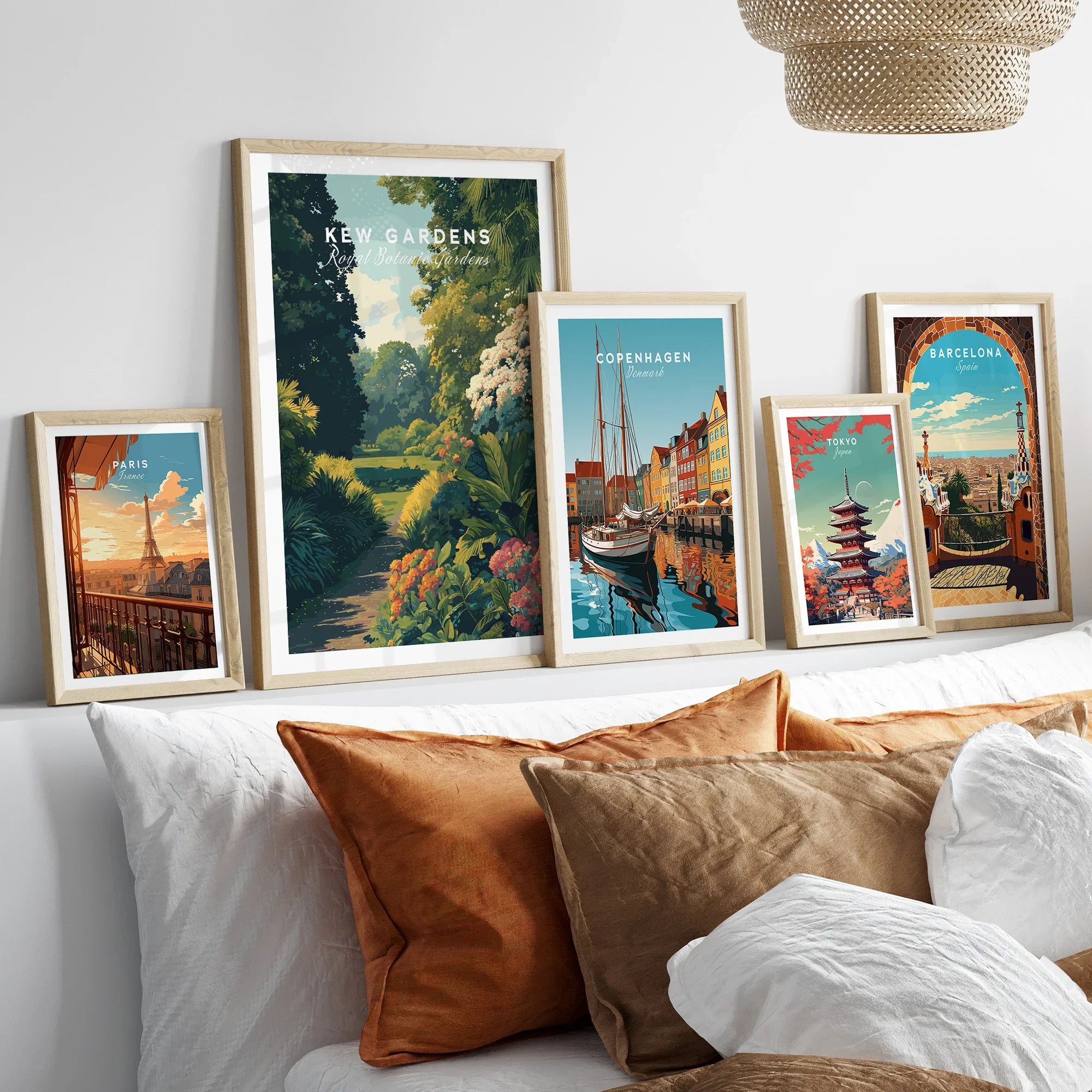 Set of five framed travel posters above bed, featuring Paris, Kew Gardens, Copenhagen, Tokyo, and Barcelona.