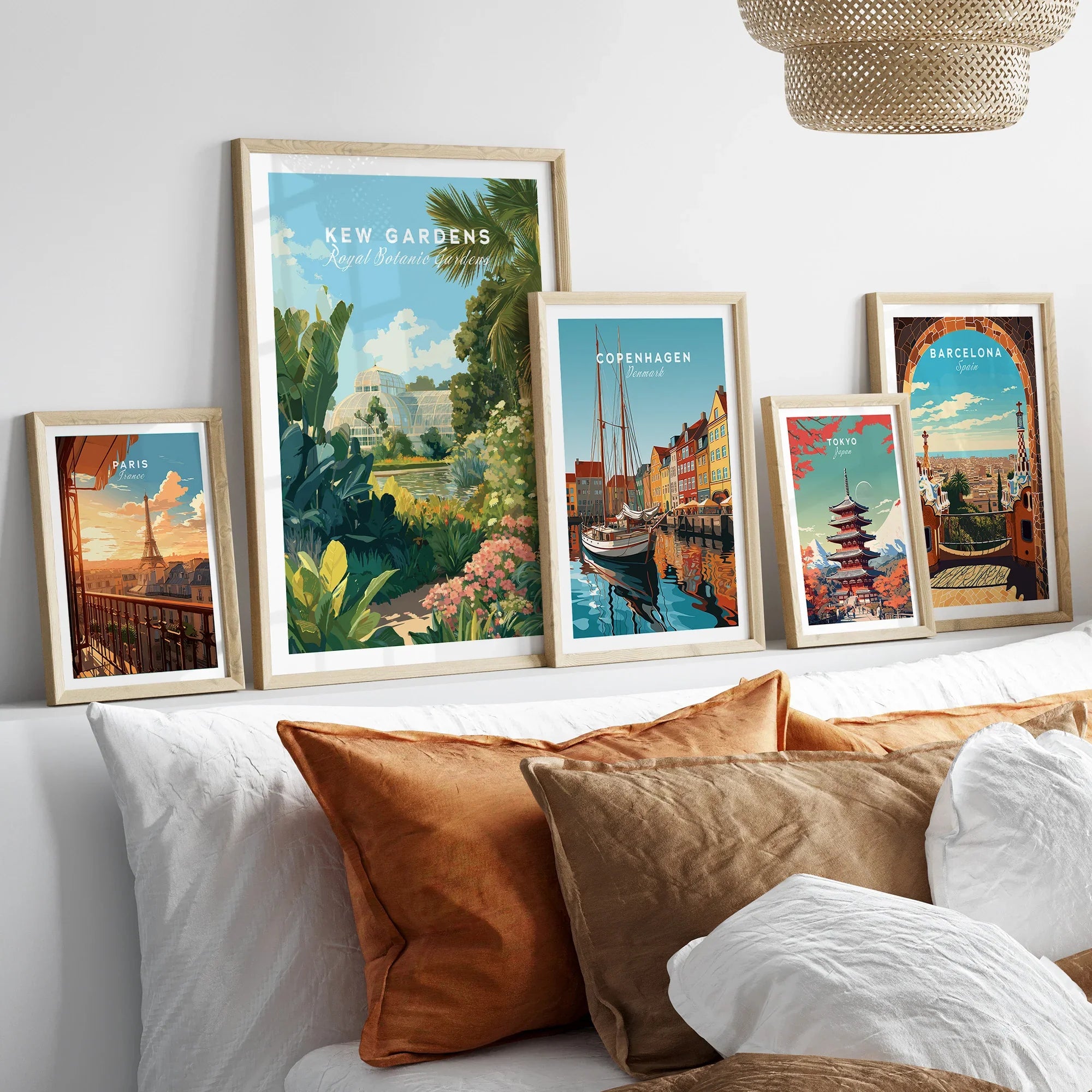 Set of five framed travel art prints above bed, including Paris, Kew Gardens, Copenhagen, Tokyo, Barcelona.