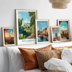 Framed travel art prints of Kew Gardens, Paris, Copenhagen, Tokyo, and Barcelona above a bed