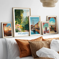 Set of five framed travel art prints above bed, featuring Paris, Kew Gardens, Copenhagen, Tokyo, Barcelona.
