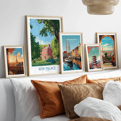 Framed travel posters of Kew Palace, Copenhagen, Paris, Tokyo, and Barcelona above a bed