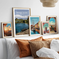 Framed travel posters featuring Paris, Komodo Island, Copenhagen, Tokyo, and Barcelona above bed