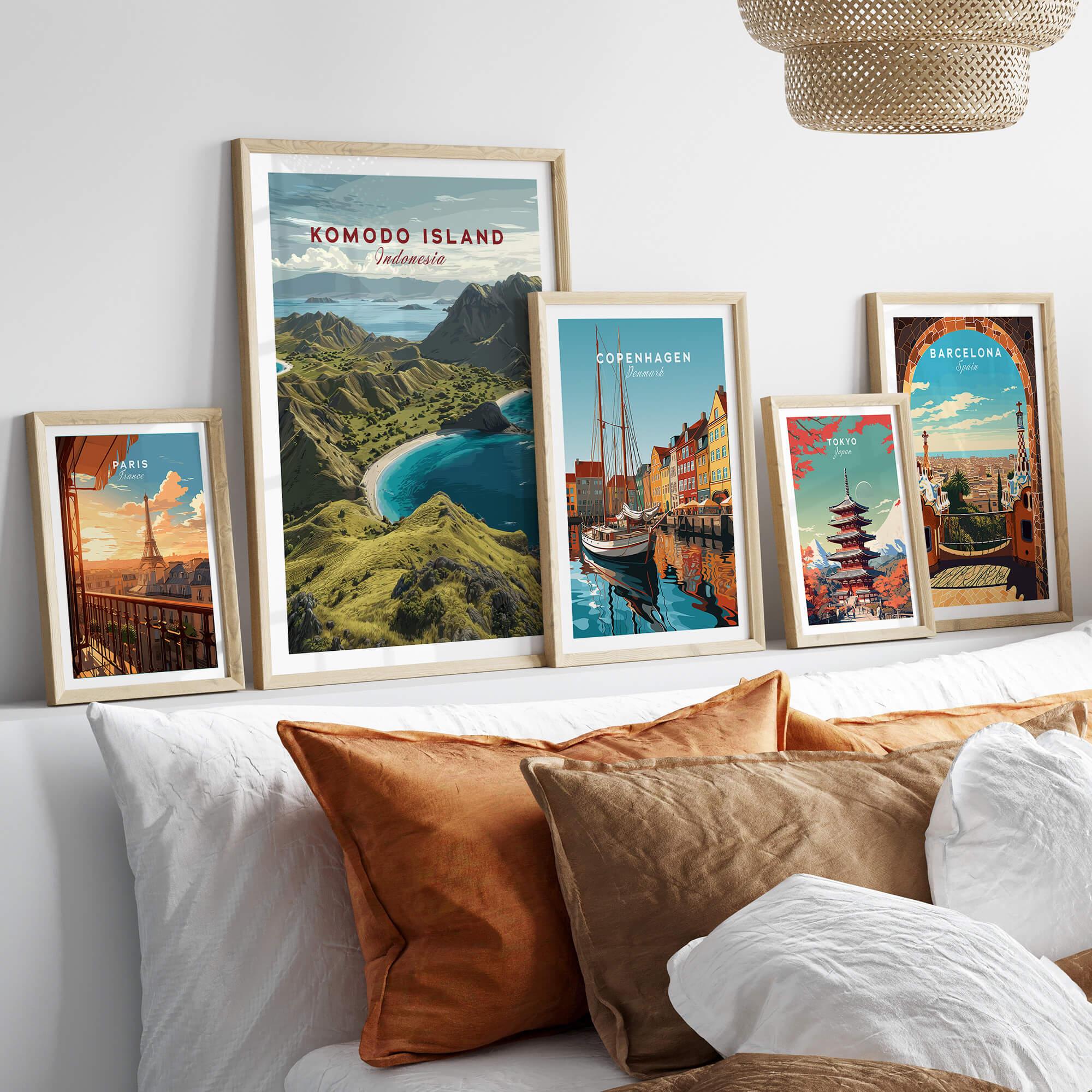 Five framed travel posters above a bed with natural wood frames and cozy pillows