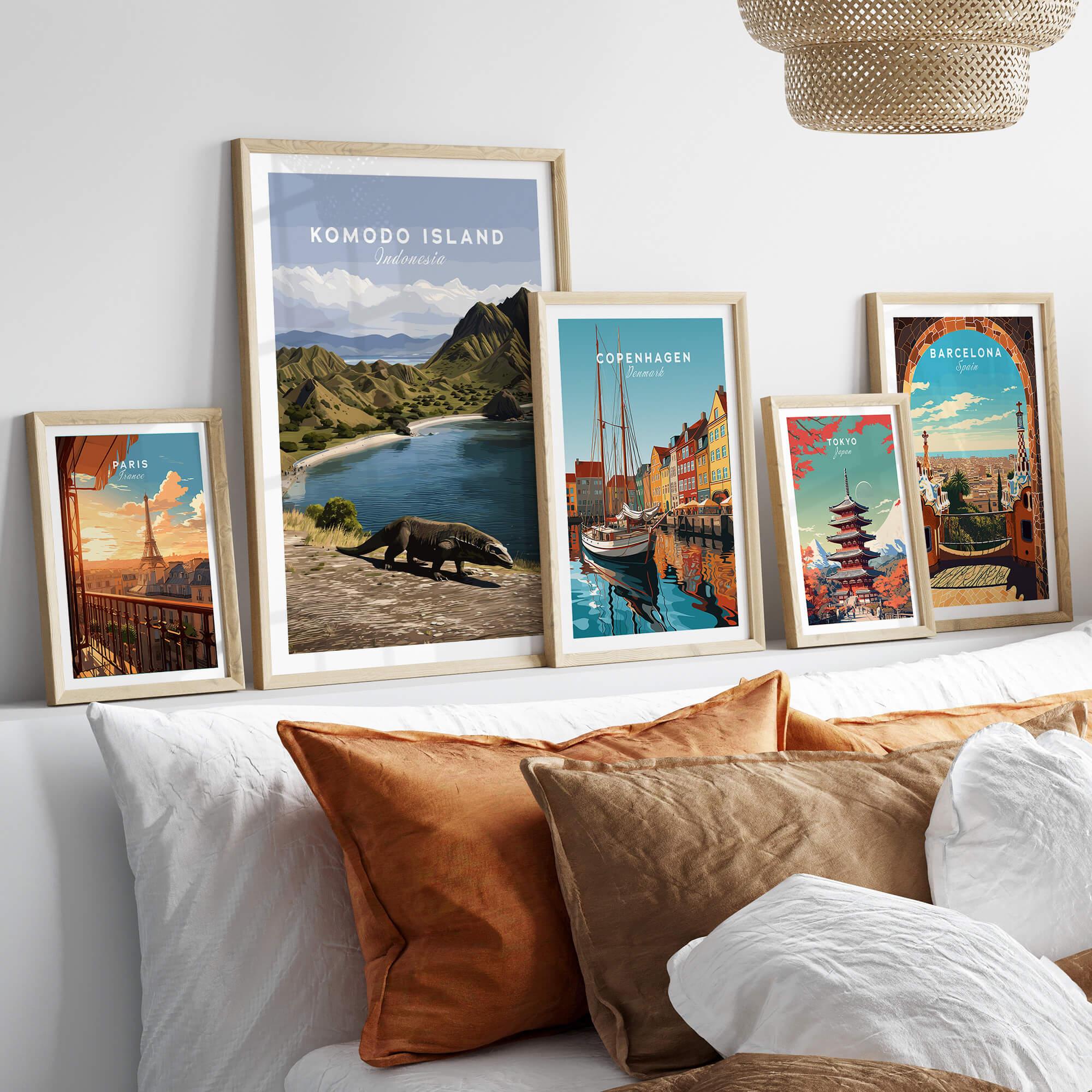 Five framed travel posters of Komodo Island, Copenhagen, Paris, Tokyo, and Barcelona above a bed