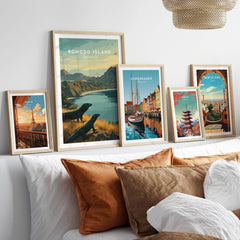 Framed travel art prints of Komodo Island, Paris, Copenhagen, Tokyo, and Barcelona above a bed.