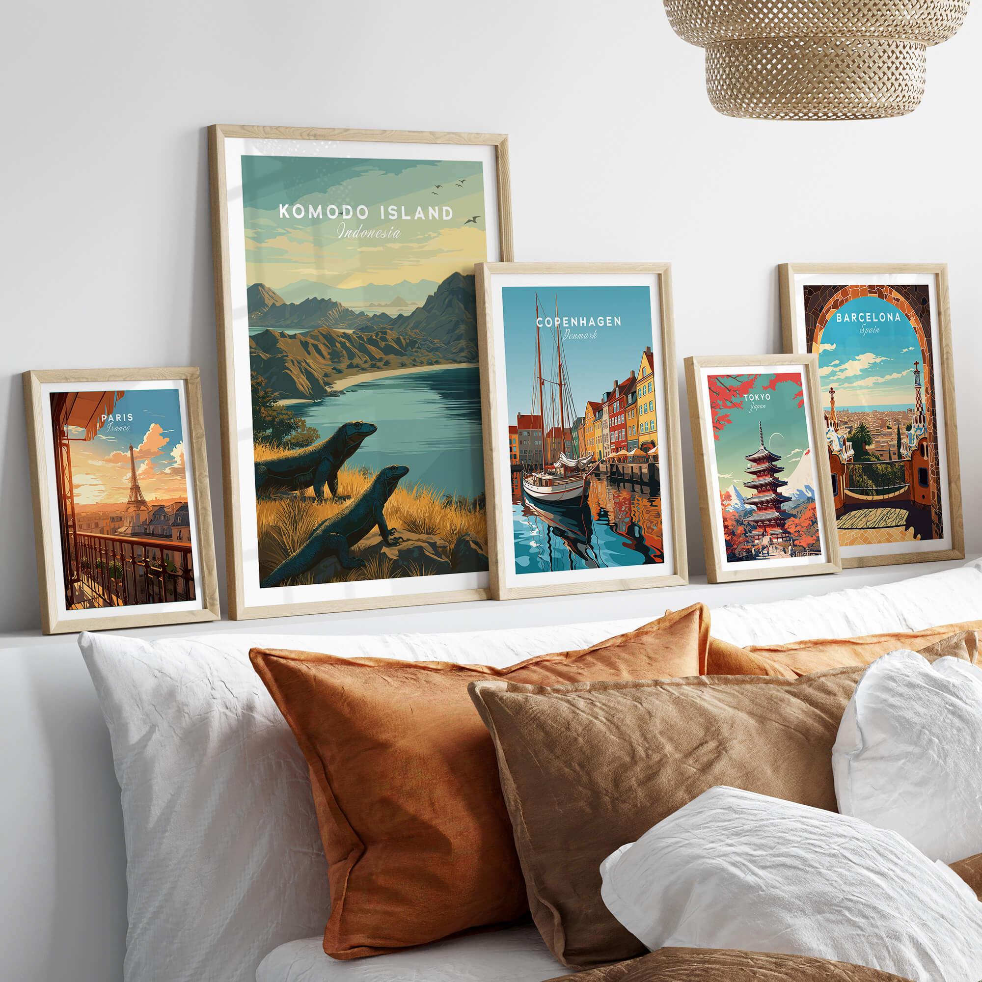 Framed travel art prints of Komodo Island, Paris, Copenhagen, Tokyo, and Barcelona above a bed.