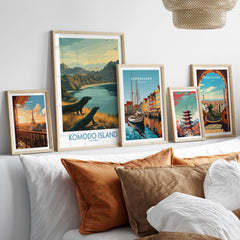 Set of five framed travel posters for Paris, Komodo Island, Copenhagen, Tokyo, and Barcelona above a bed.