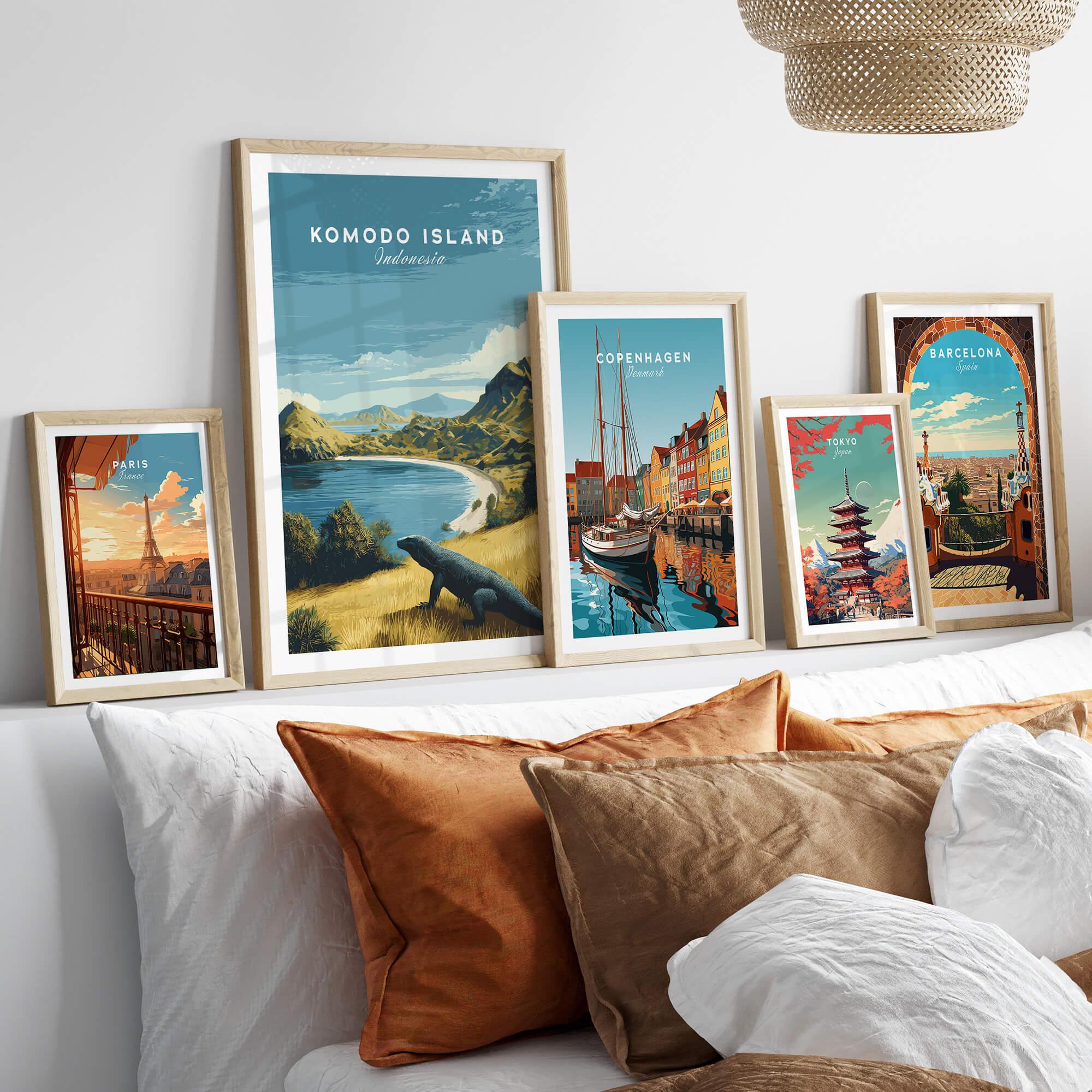 Five framed travel posters of Komodo Island, Copenhagen, Paris, Tokyo, and Barcelona above a bed.