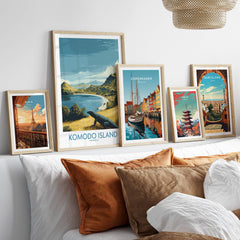 Framed travel posters of Paris, Komodo Island, Copenhagen, Tokyo, and Barcelona above a bed