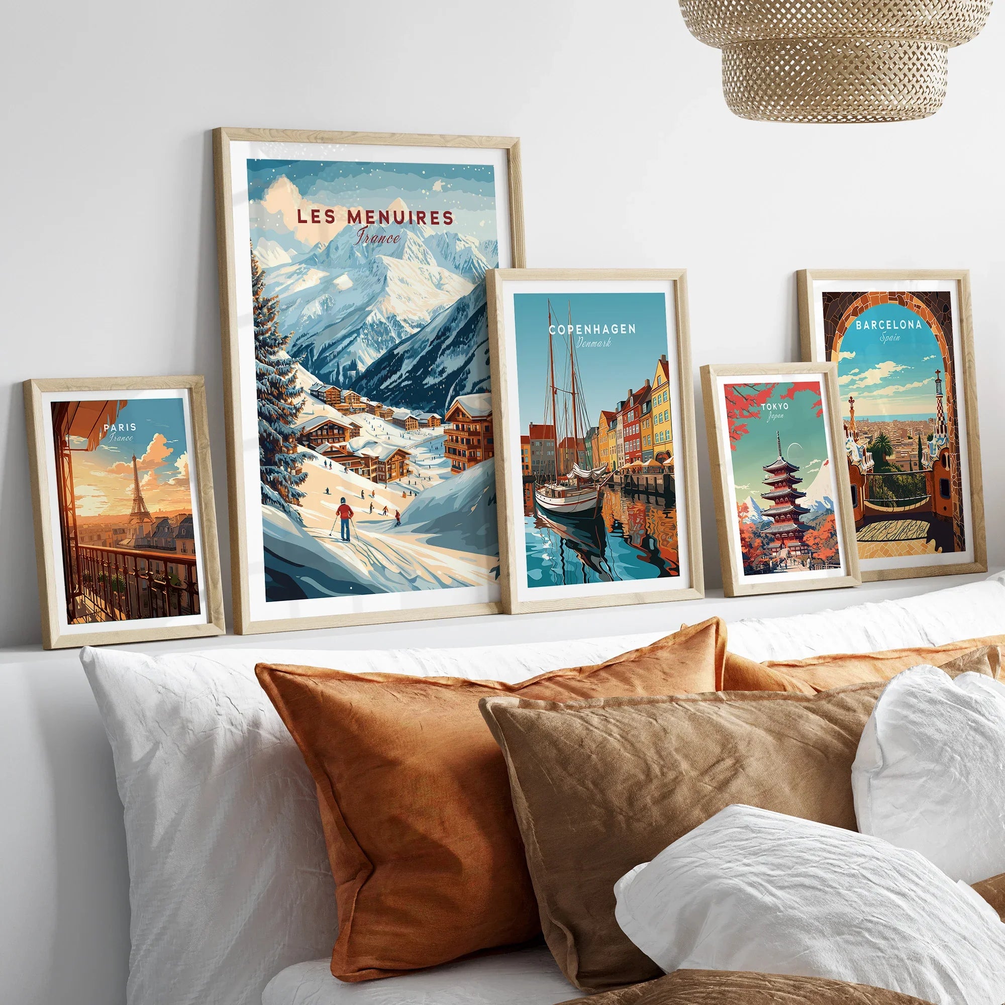 Framed travel posters of Paris, Les Menuires, Copenhagen, Tokyo, and Barcelona above bed