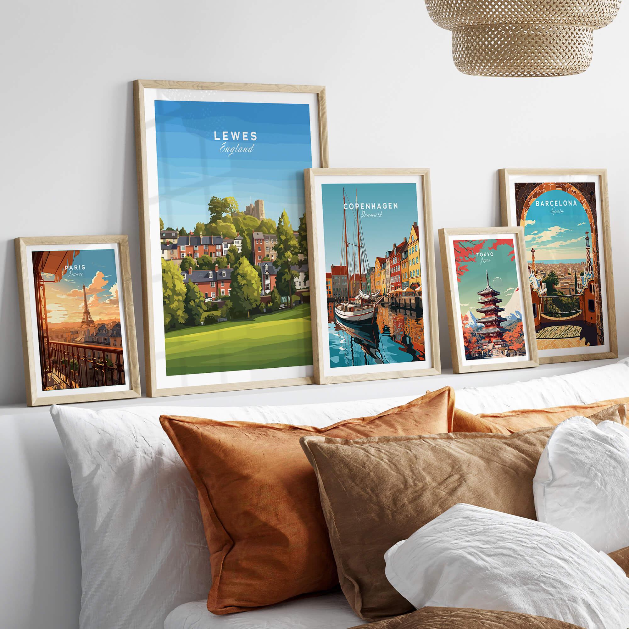 Framed travel posters of Lewes, Paris, Copenhagen, Tokyo, and Barcelona above a bed.