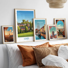 Five framed travel posters of global cities above a bed with natural wood frames.