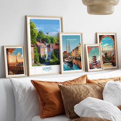 Five framed travel posters with city landmarks above bed, neutral wood frames, cozy decor