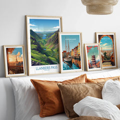Set of five framed travel posters above bed, featuring Paris, Llanberis Pass, Copenhagen, Tokyo, and Barcelona.