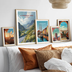 Set of five framed travel posters above a bed, featuring scenic city and nature wall art.