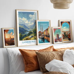 Framed travel art prints of Paris, Snowdonia, Copenhagen, Tokyo, and Barcelona above a bed.