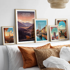Set of five framed travel art prints above bed, featuring Paris, Loch Lomond, Copenhagen, Tokyo, Barcelona.