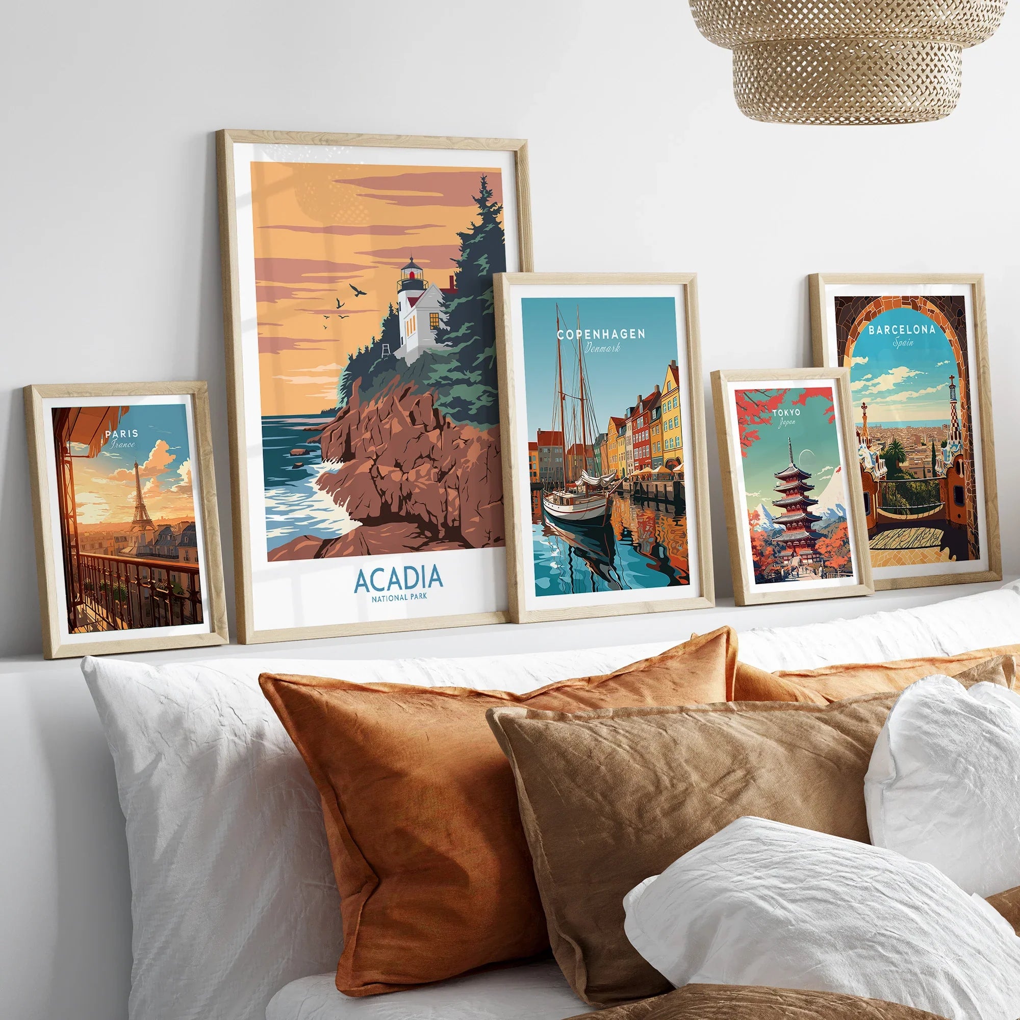 Framed travel posters of Acadia, Paris, Copenhagen, Tokyo, and Barcelona above a bed