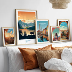 Set of five framed travel posters above bed, featuring Banff, Paris, Copenhagen, Tokyo, Barcelona.