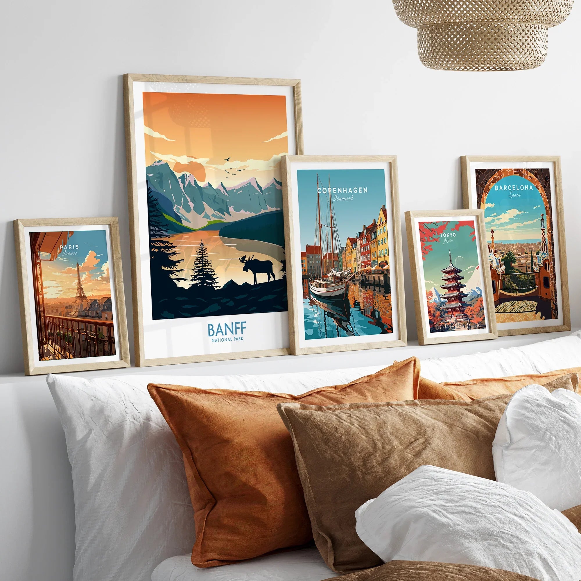 Set of five framed travel posters above bed, featuring Banff, Paris, Copenhagen, Tokyo, Barcelona.