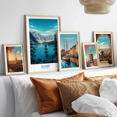 Framed travel posters of Banff, Paris, Copenhagen, Tokyo, and Barcelona above a bed