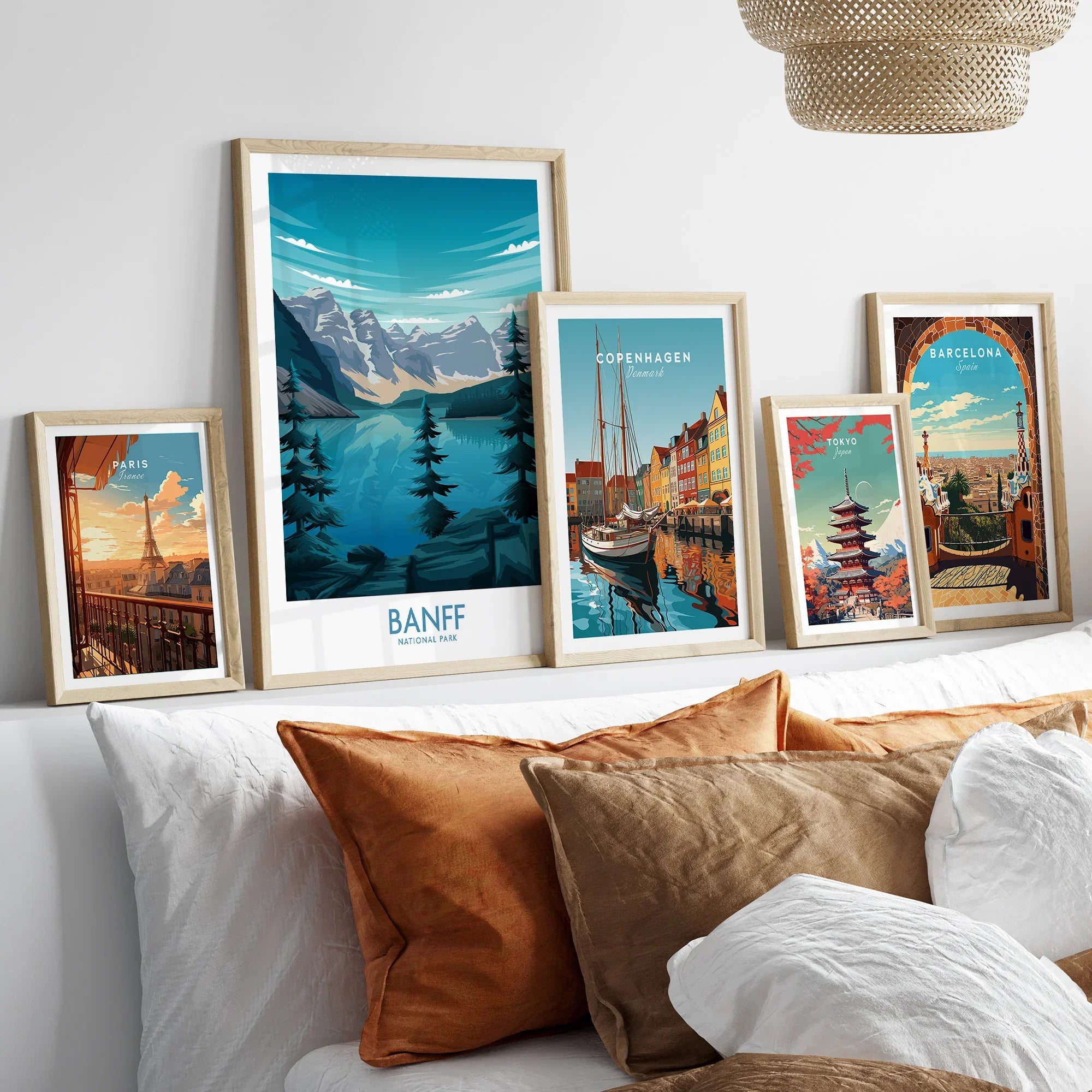 Framed travel posters of Banff, Paris, Copenhagen, Tokyo, and Barcelona above a bed